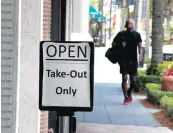  ??  ?? A takeout sign is placed in front of a restaurant on Las Olas Boulevard in Fort Lauderdale.