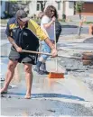  ?? PHOTO: IAIN McGREGOR/FAIRFAX NZ ?? Gary Bell among neighbours shovelling liquefacti­on on Linkwater Way, Parklands.
