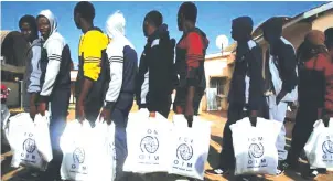  ??  ?? Gambian migrants returning home from Libya carry bags from UN agency the Internatio­nal Organizati­on for Migration.