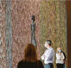  ?? Mark Mulligan / Staff photograph­er ?? Jason Salavon’s newly commission­ed site-specific wallpaper “Little Infinities (v. MFAH)” surrounds the photograph­y galleries near Alberto Giacometti’s “Large Standing Woman I.”