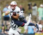  ?? BRETT COOMER - THE ASSOCIATED PRESS ?? New England Patriots wide receiver Chris Hogan (15) leaps up over Houston Texans cornerback Kevin Johnson (30) to catch a pass during a joint NFL football practice, Tuesday, in White Sulphur Springs, W.Va.