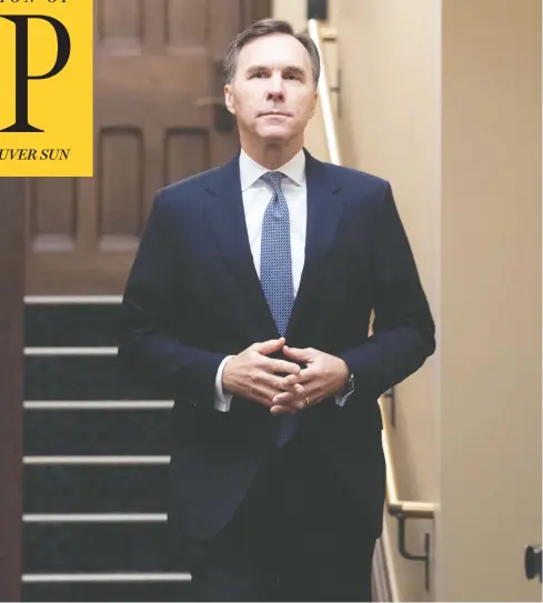  ?? ADRIAN WYLD / THE CANADIAN PRESS ?? Finance Minister Bill Morneau makes his way to the podium to provide a fiscal update in the foyer of Parliament Hill’s West Block on Monday.