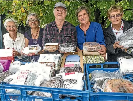  ?? PHOTO: DOUG FIELD/STUFF ?? Fiona Elworthy, Sonia Henare, Warwick Smith, Jenny Smith and Val Whitewith some of the 65 fruitcakes going to flood affected West Coasters.