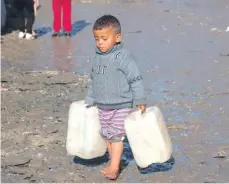  ?? ?? A young boy carries empty jerricans in Rafah in the southern Gaza Strip yesterday, as fighting continues between Israel and the Palestinia­n Hamas group. PHOTO: MOHAMMED ABED/AFP