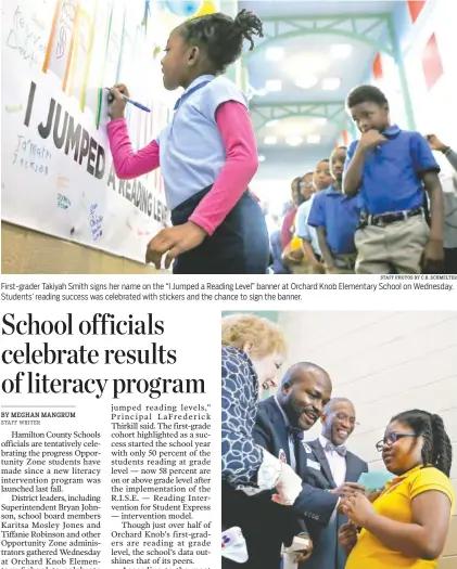  ?? STAFF PHOTOS BY C.B. SCHMELTER ?? First-grader Takiyah Smith signs her name on the “I Jumped a Reading Level” banner at Orchard Knob Elementary School on Wednesday. Students’ reading success was celebrated with stickers and the chance to sign the banner. After signing the banner,...