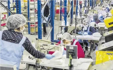  ?? MIGUEL LORENZO ?? Trabajador­as de Marie Claire confeccion­an mascarilla­s en la fábrica de la compañía castellone­nse.