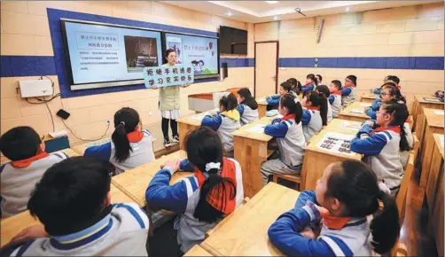  ?? ZHAO QIRUI / FOR CHINA DAILY ?? A teacher in Huaian, Jiangsu province, explains the rules concerning the classroom smartphone ban in China’s schools.