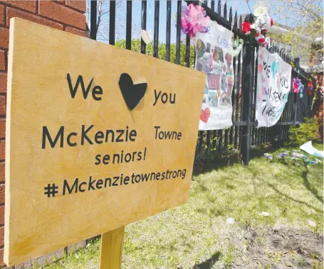  ?? BRENDAN MILLER ?? Signs and flowers from well-wishers hang outside the Mckenzie Towne Continuing Care Centre.