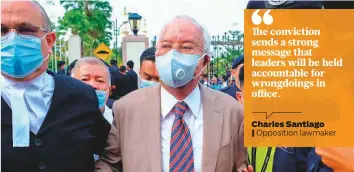  ?? Bloomberg ?? Najib Razak, Malaysia’s former prime minister, center, wears a protective mask as he arrives at the Kuala Lumpur Courts Complex in Kuala Lumpur, Malaysia yesterday.