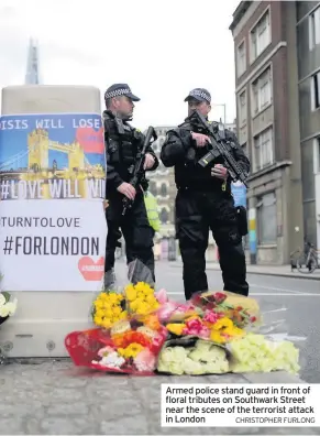  ?? CHRISTOPHE­R FURLONG ?? Armed police stand guard in front of floral tributes on Southwark Street near the scene of the terrorist attack in London