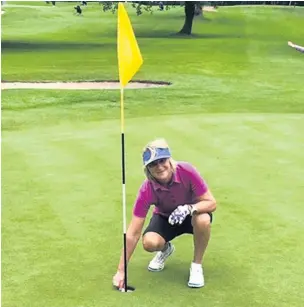  ??  ?? ●● Colette retreiving her ball from the hole after her fantastic hole-in-one