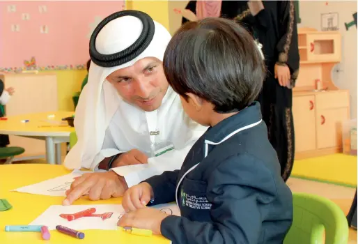  ?? Supplied photo ?? Dr Abdulla Al Karam, director-general of Knowledge and Human Developeme­nt Authority (KHDA) interacts with a toddler during a visit to one of the schools in Dubai. Happiness of students lies at the core agenda of the KHDA, which is trying to introduce more wellbeing and happiness practices into Dubai’s schools. —