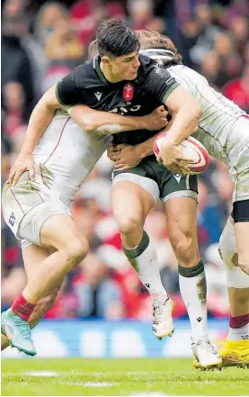  ?? Photo / AP ?? Louis Rees-Zammit of Wales attempts to offload in a double tackle by Georgia defenders in Cardiff.
