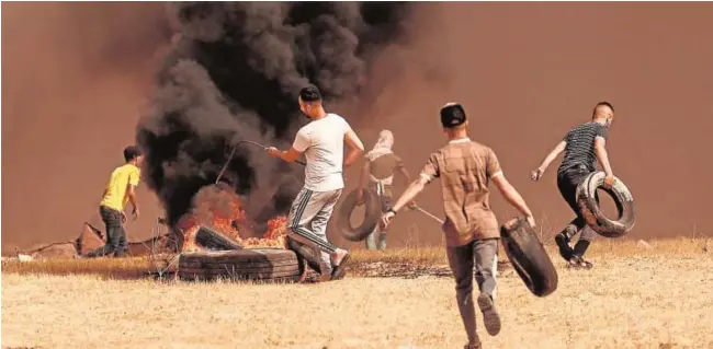 ?? AFP ?? Manifestan­tes palestinos queman neumáticos en una protesta en Gaza