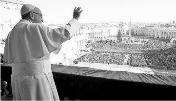  ??  ?? Pope Francis waves as he leads the ‘Urbi et Orbi’ (to the city and the world) message from the balcony overlookin­g St. Peter’s Square at the Vatican. — Reuters photo