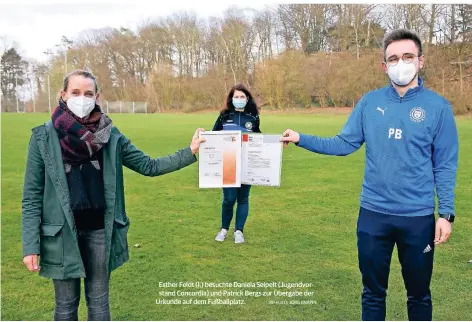  ??  ?? Esther Feldt (l.) besuchte Daniela Seipelt (Jugendvors­tand Concordia) und Patrick Bergs zur Übergabe der Urkunde auf dem Fußballpla­tz.