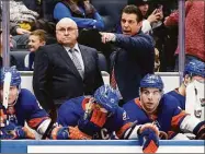  ?? Jim McIsaac / Associated Press ?? Islanders head coach Barry Trotz, left, and assistant coach Lane Lambert stand on the bench during a January game against the Flyers. The Islanders hired Lambert to succeed Trotz as coach on Monday.