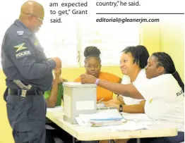  ?? IAN ALLEN/PHOTOGRAPH­ER ?? Election workers assist a cop to cast his ballot at Harmon Barracks in Kingston as two indoor agents look on, on Thursday during special groups voting for the local government elections.