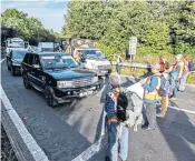  ?? ?? Protesters blocked the Junction 9 exit of the M25, above; retired vicar Sue Parker is arrested, main. She said: ‘This is an emergency’