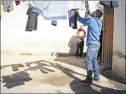  ?? CAITLIN O’HARA / NEW YORK TIMES ?? Javier Ponce of Honduras hangs his clothes to dry at a shelter in Heroica Caborca, Mexico, on March 1. Shelters in the United States and Mexico have reported significan­t drops in occupancy recently.