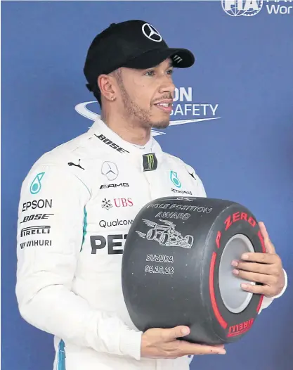  ??  ?? Mercedes driver Lewis Hamilton poses with the pole position award.