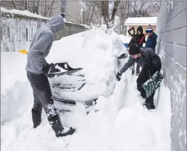  ?? CP PHOTO ?? People remove snow from around a car yesterday in Dartmouth.