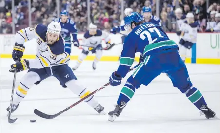  ??  ?? Sabres centre Ryan O’Reilly tries to make a move around Canucks defenceman Ben Hutton on Thursday.