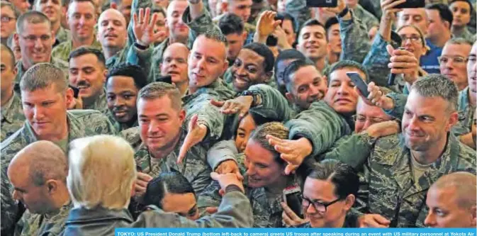  ?? —AFP ?? TOKYO: US President Donald Trump (bottom left-back to camera) greets US troops after speaking during an event with US military personnel at Yokota Air Base in Tokyo yesterday.