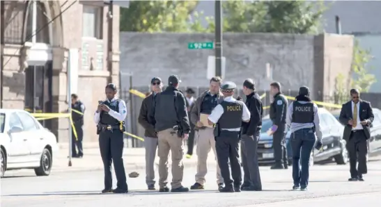  ?? ASHLEE REZIN/SUN-TIMES ?? Chicago police on Monday investigat­e in the 9200 block of South Cottage Grove after six people were shot following a funeral service.