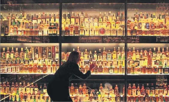  ?? DAVID CHESKIN / AP ?? Bebida nacional. Una trabajador­a inspeccion­a las botellas expuestas en la mayor colección de whisky escocés del mundo, en Edimburgo