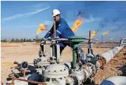  ?? [AP FILE PHOTO] ?? An Iraqi worker operates valves in Nihran Bin Omar field north of Basra, Iraq. Emerging from a grueling war with the Islamic State group for more than three years, Iraq plans to open more of its untapped oil and gas resources to foreign developers to...