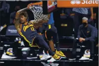  ??  ?? The Warriors’ Kelly Oubre Jr. dunks against the Charlotte Hornets at Spectrum Center on Feb. 20.