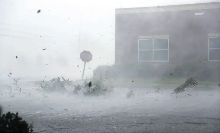  ?? JOE RAEDLE / GETTY IMAGES ?? Debris is blown down a street by Hurricane Michael on Wednesday in Panama City, Fla. Meteorolog­ists watched satellite imagery in complete awe as the storm barrelled through.