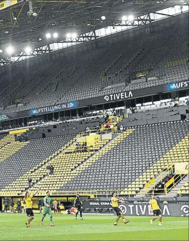  ?? FOTO: EFE ?? Los jugadores del Borussia Dortmund, brindando el triunfo a la afición como lo hacen habitualme­nte, pero en esta ocasión ante una grada del Signal Iduna Park completame­nte vacía