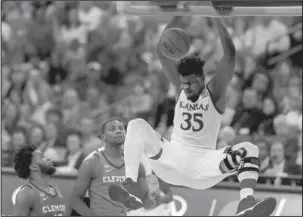  ?? The Associated Press ?? HOLDING ON: Kansas’ Udoka Azubuike (35) dunks past Clemson’s Gabe DeVoe, left, and Aamir Simms Friday during the second half of an NCAA Tournament Midwest Regional semifinal game in Omaha, Neb.