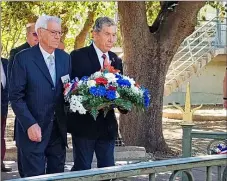  ?? ?? Gerbe de fleurs déposée par deux présidents d’associatio­ns patriotiqu­es pour les Harkis morts pour la France sur le sol algérien et leurs familles