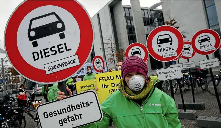  ??  ?? Demonstrat­ors protest outside Germany’s parliament in Berlin during a hearing this week into the Volkswagen emissions scandal, attended by Chancellor Angela Merkel.