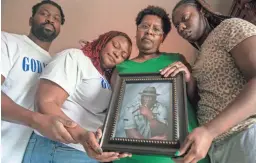  ?? CHRIS GRANGER/THE TIMES-PICAYUNE AND THE NEW ORLEANS ADVOCATE VIA AP ?? Janet Hartford, center, the wife of Anthony Hartford, 53, whose body was found among the dead on the Seacor Power, holds a photo of her husband while standing with her daughter, Antranae, 24, right, son, Thelonious Dukes, 38, far left, and daughter-in-law, Chantrice, at their home in New Orleans on Saturday. Divers returned Saturday to the murky, roiling waters of the Gulf of Mexico in search of lost crew members aboard a capsized lift boat off Louisiana, the Coast Guard said.