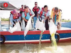  ?? [FOTO AMIR IRSYAD OMAR/BH] ?? Pengerusi Jawatankua­sa Pertanian, Industri Asas Tani, Perusahaan Perladanga­n dan Komoditi Negeri, Datuk Muhammad Pehimi Yusof (dua dari kanan) melepaskan benih ikan kelah ke Sungai Jertih, semalam.