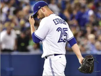  ?? FRANK GUNN, THE CANADIAN PRESS ?? Blue Jays starter Marco Estrada walks back to the dugout after being taken out of the game in the fifth inning against the Tampa Bay Rays in American League baseball action in Toronto on Tuesday night. Estrada lasted just 4 1/3 innings, allowing 10...