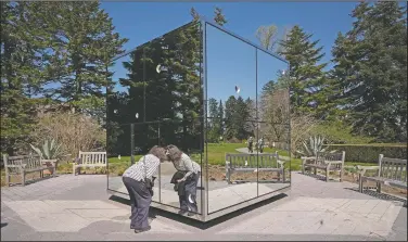  ??  ?? A woman peers into the sculpture Infiniti Mirrored Room-Illusion Inside the Heart.