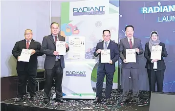  ??  ?? Yap (middle) posing with Radiant’s prospectus along with other board members of the group yesterday.