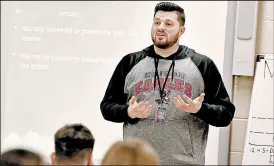  ??  ?? Health/physical education instructor Justin Fidnarik teaches his high school class about body weight and nutrition at Lake Station Edison High on Wednesday.