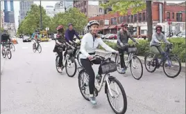  ?? Steve MacNaull photo ?? Hike group cycles through Fulton Market District, the former meat-packing district turned restaurant and tech hotspot.