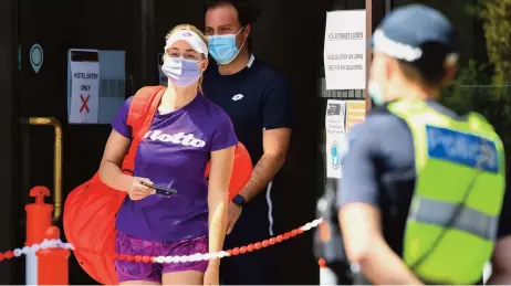  ??  ?? A tennis player and coach leave their hotel to train in Melbourne on Sunday, as 47 players quarantine in hotels ahead of the Australian Open tennis tournament in February