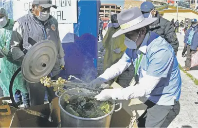  ?? Picture: AFP ?? NATURAL WAY. A doctor explains to customers how the first natural disinfecti­on tunnel of medicinal plants works in El Alto, Bolivia. These are some of the wild plants that face extinction due to high demand.