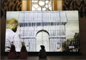  ??  ?? Children watch a video on “L’Arc de Triomphe, Wrapped” in Paris on Tuesday.