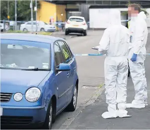  ??  ?? Scene A forensic team search the street for evidence following the death of Mr Boyle