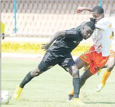  ?? (Pic: Mengameli Mabuza) ?? Mbabane Highlander­s striker Kwado Frimpong (L) challenged Ezulwini United player Mthobisi Zwane in an aggressive manner, during yesterday’s MTN Premier League match at Mavuso Sports Centre.