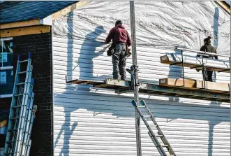  ?? NICK GRAHAM / STAFF ?? Crews install siding on a house being built by Cristo Homes on Governors Avenue on Feb. 21 in Trenton.